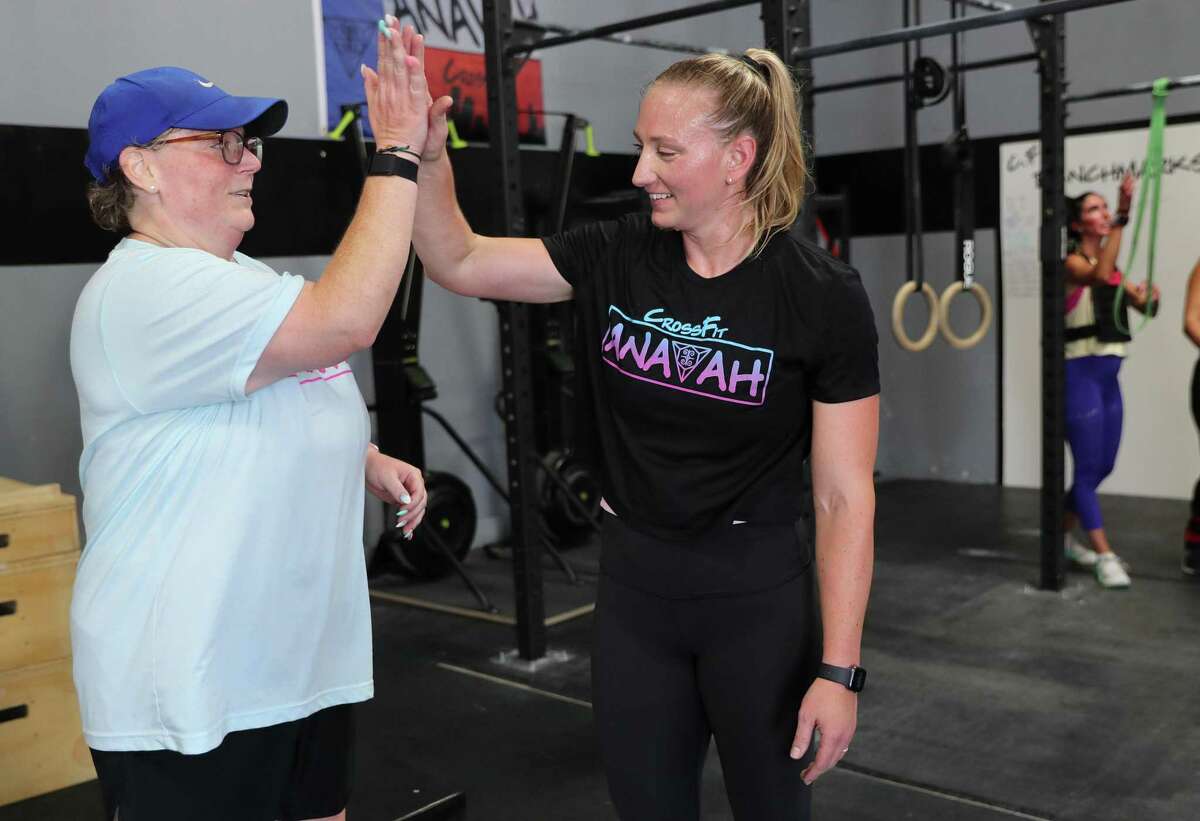 CrossFit Anavah members Amanda Drake and Dr. Afton McNierny congratulate each other after finishing a set of repetitions at the gym on Monday, May 16, 2022 in Spring. Amanda Drake went to the ER not feeling well, her ER doctor Dr. Afton McNierny discovered that she was having an aneurysm and ended up saving her life. Later, the two realized they knew each other from CrossFit. They go to the same gym. Amanda is still in rehab, she was in a coma for a month. Now the two are friends.