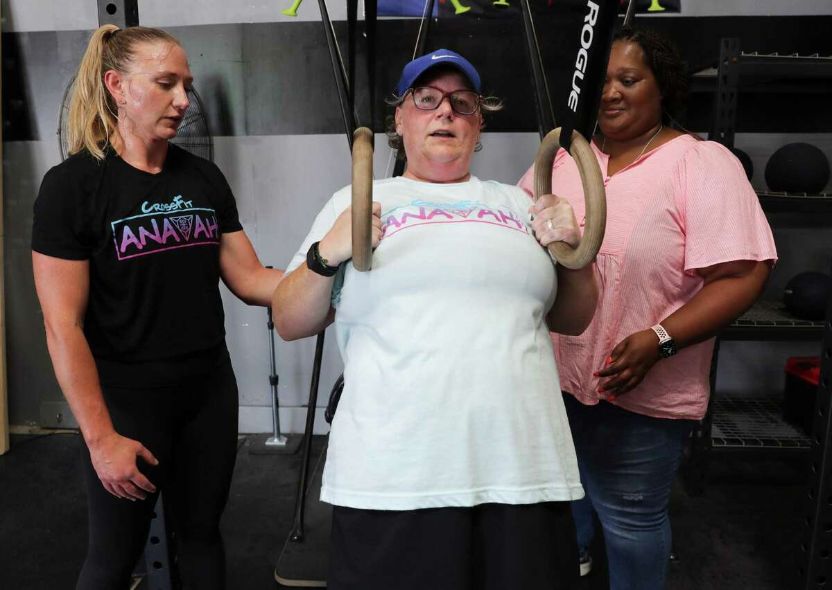 Dr. Afton McNierny spots Amanda Drake along with caretaker Tamara Brown at CrossFit Anavah gym on Monday, May 16, 2022 in Spring. Amanda Drake went to the ER not feeling well, her ER doctor Dr. Afton McNierny discovered that she was having an aneurysm and ended up saving her life. Later, the two realized they knew each other from CrossFit. They go to the same gym. Amanda is still in rehab, she was in a coma for a month. Now the two are friends.