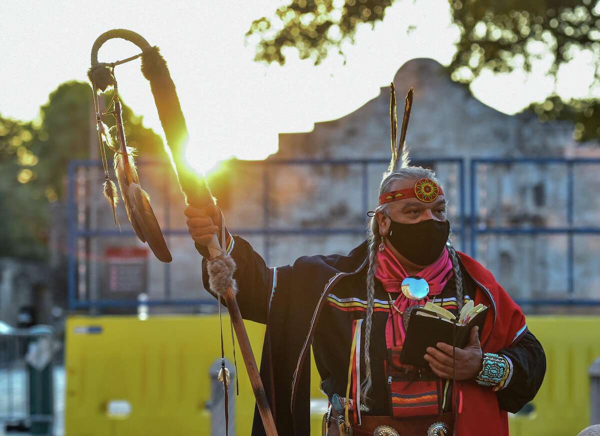 Papabear, artist Isaac Cardenas Cona of the Tap Pilam Coahuiltacan Nation leads a prayer during their 25th annual sunrise ceremony and runs past the Alamo Saturday morning to honor the ancestors buried inside the Texas shrine.