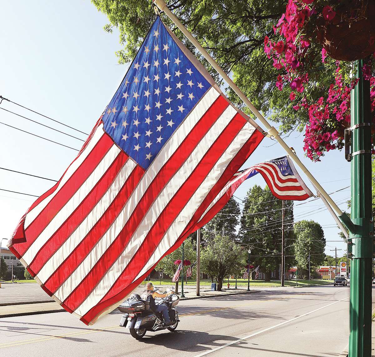 A motorcyclist rides past one of the many American flags set out on Washington Avenue in Upper Alton Tuesday for Flag Day. June 14, 1777, is the day the American flag was adopted, establishing the colors and pattern of the flag.