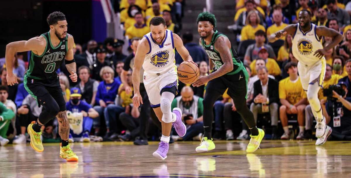 Warriors guard Stephen Curry darts upcourt with the Boston Celtics’ Jayson Tatum (left) and Marcus Smart in Game 5 at Chase Center on Monday.