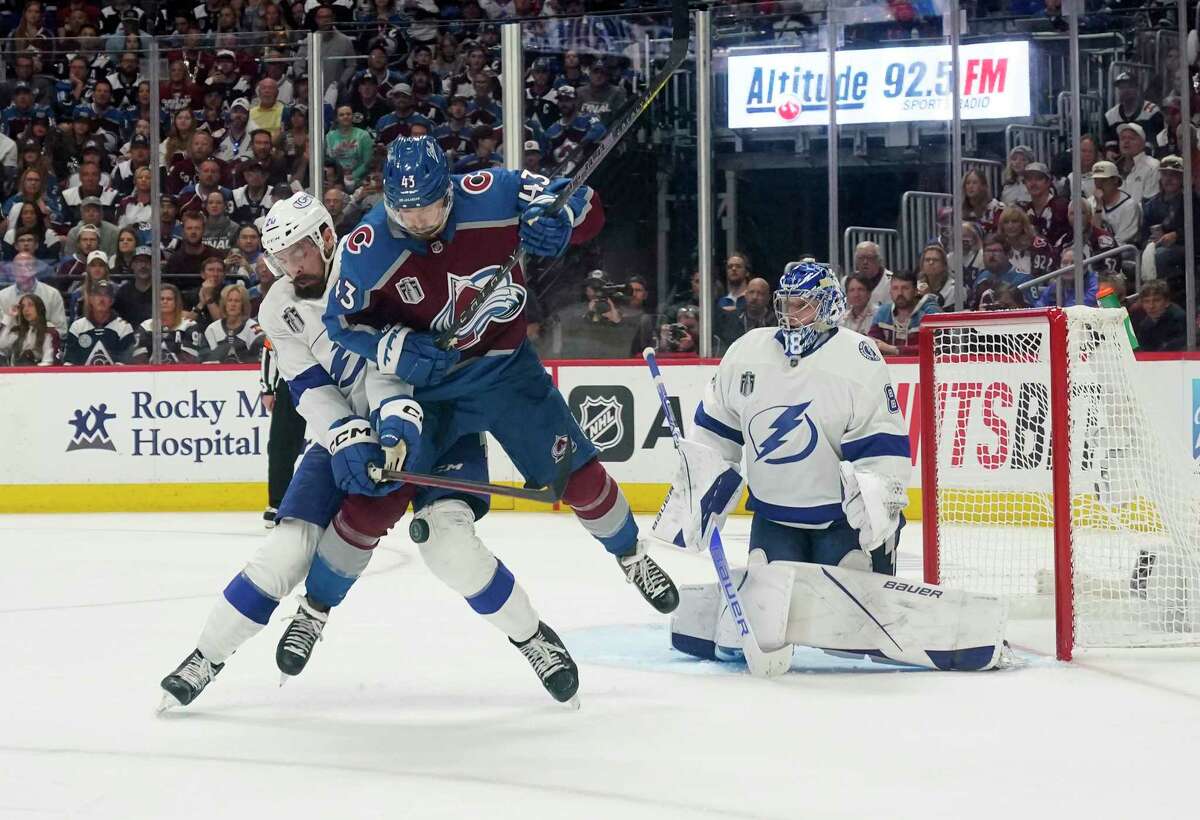 Tampa Bay Lightning left wing Nicholas Paul (20) and Colorado Avalanche center Darren Helm (43) tangle in front of Lightning goaltender Andrei Vasilevskiy (88) during the third period of Game 1 of the NHL hockey Stanley Cup Final on Wednesday, June 15, 2022, in Denver.