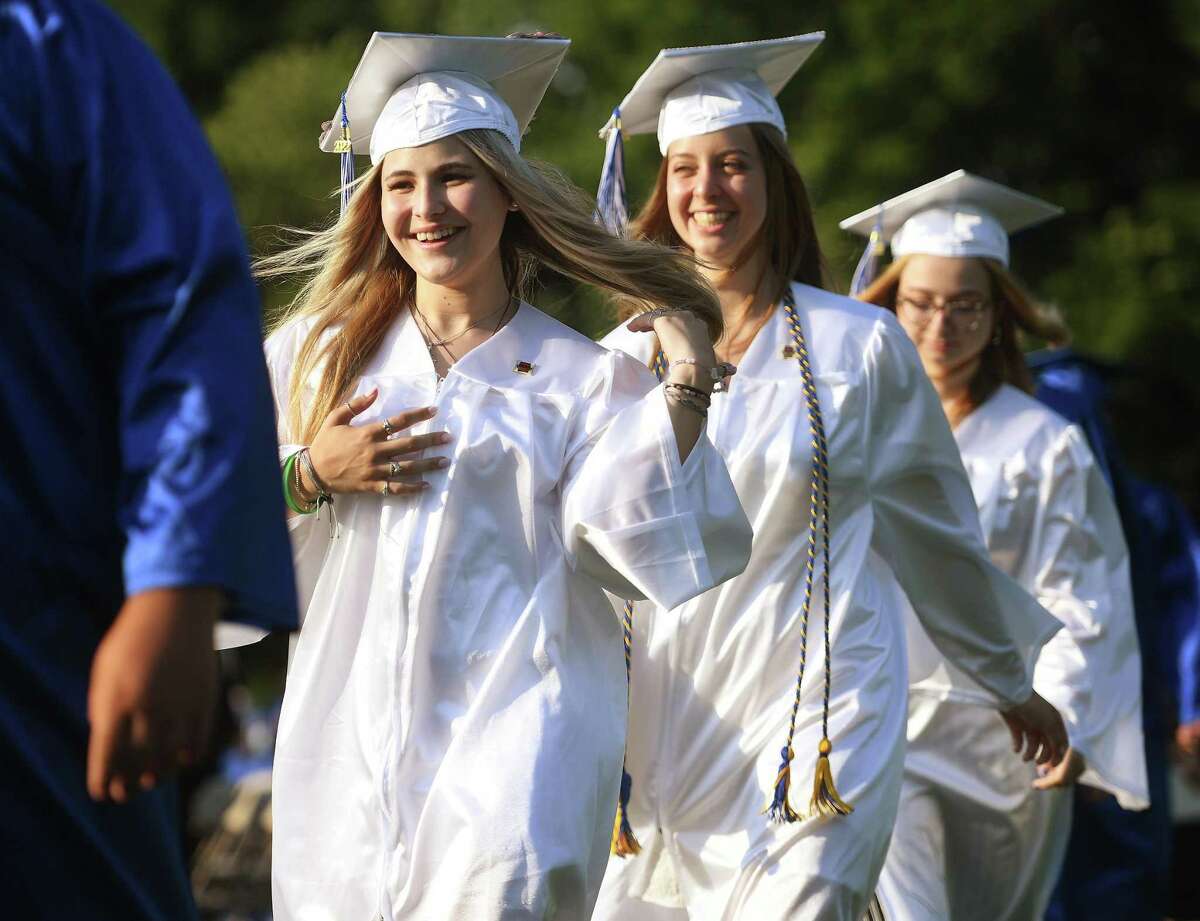 From left; Graduates Ashley Gotch, Elisabeth Gotschlich, and their classmates walk up to receive their diplomas at the Newtown High School Graduation in Newtown, Conn. on Wednesday, June 15, 2022.