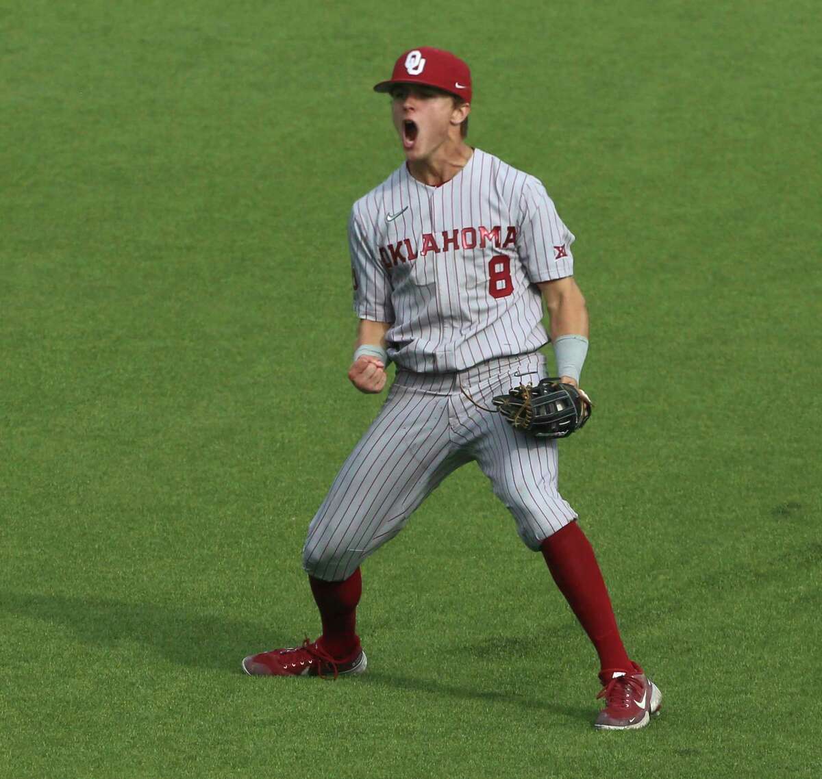 Oklahoma's John Spikerman (8) celebrates after catching a fly ball in right field for the final out against Virginia Tech in an NCAA college baseball super regional game in Blacksburg, Va., Friday, June 10, 2022. (AP Photo/Matt Gentry)