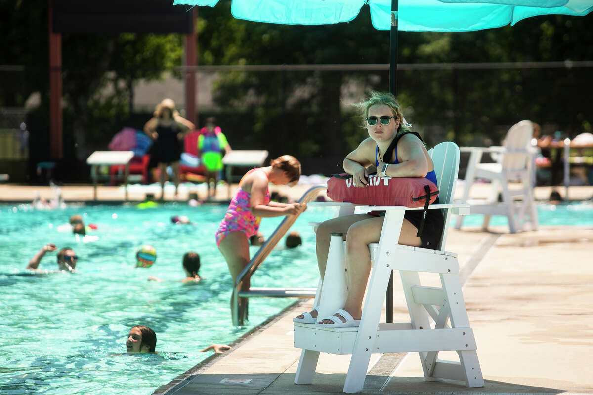 Lifeguard Natalie Nussear, 17, watches from her post as families cool off from temperatures in the high 80s at Plymouth Pool Thursday, June 16, 2022 in Midland.