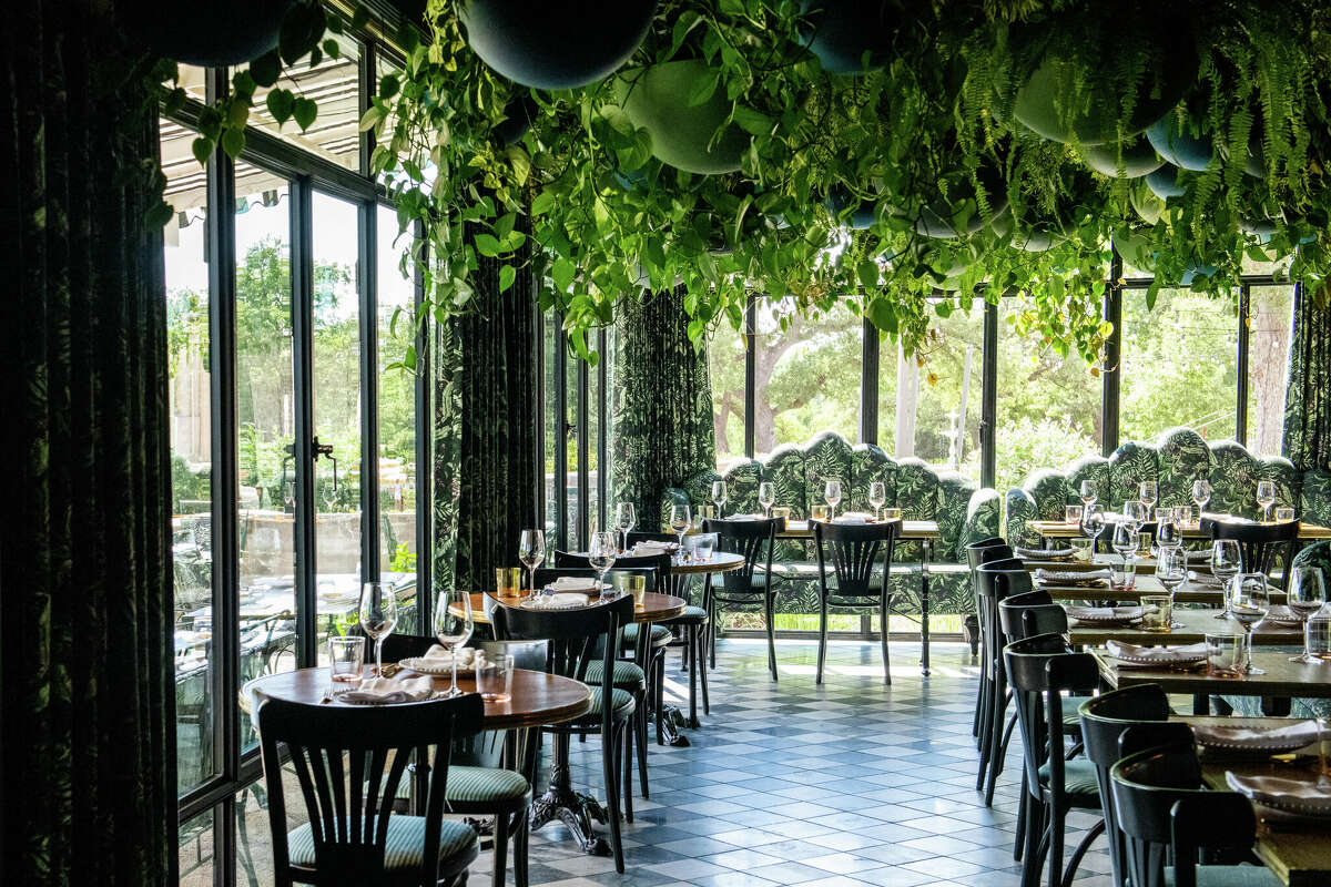 The interior decor of Lutie's Garden Restaurant, designed by Ken Fulk, is a modern interpretation of a sophisticated country club. The garden-themed eatery features live plants dangling from the ceiling. 