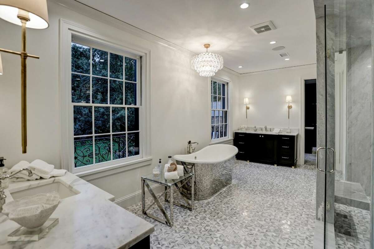 The primary bathroom has marble flooring and a soaking tub.