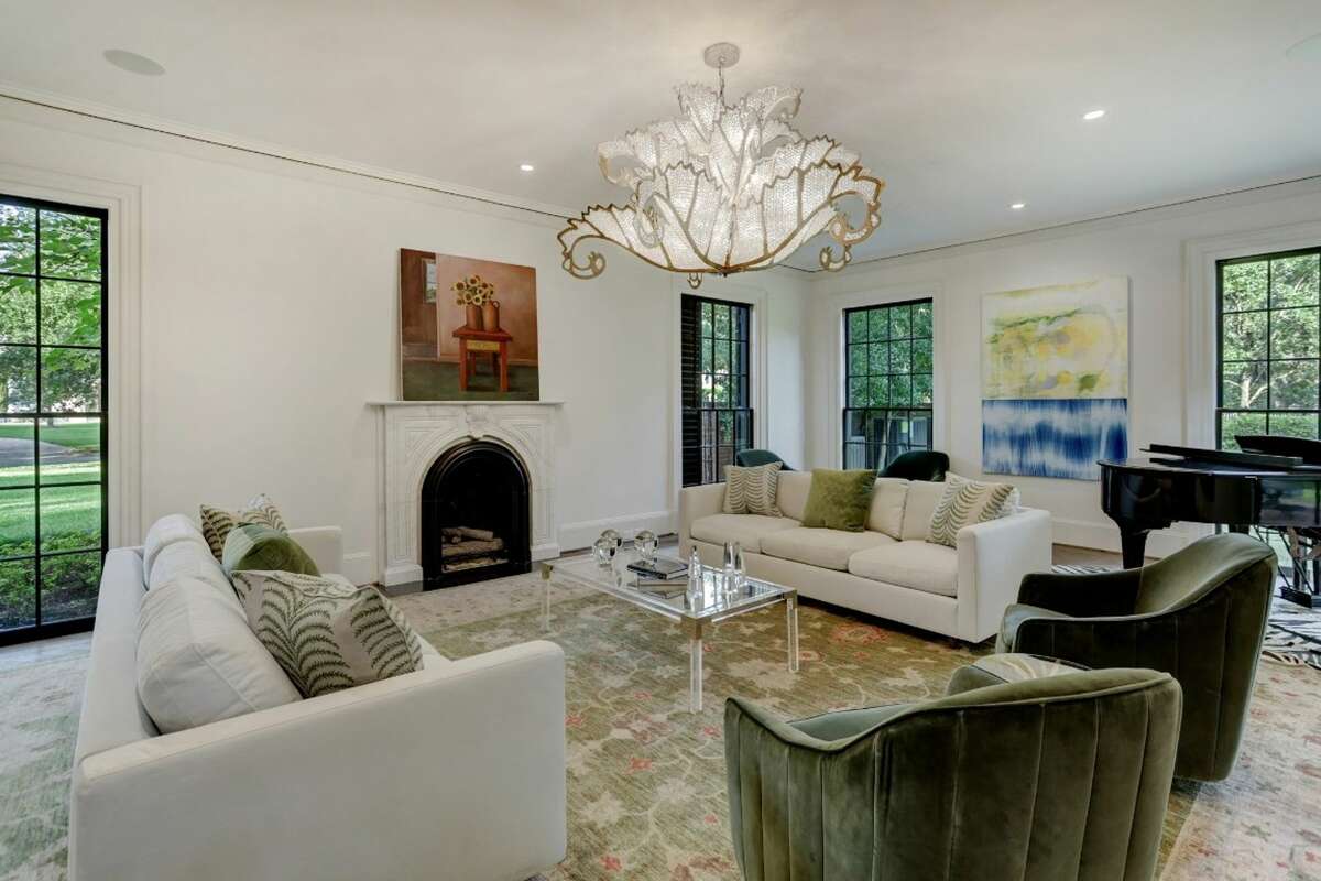 The formal living room has French oak flooring, a marble fireplace and artisan chandelier.
