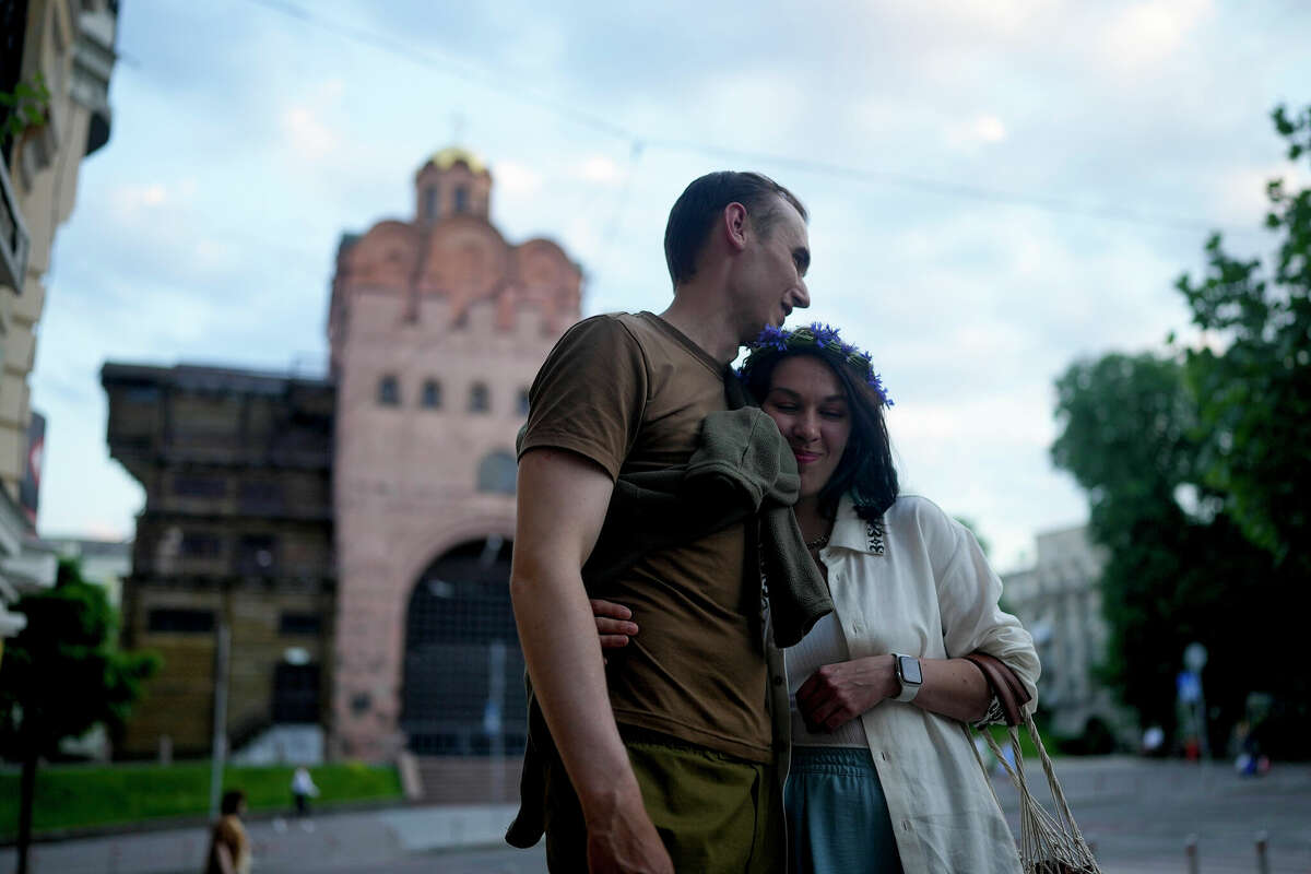 Stand-up comics Serhiy Lipko and Anastasia Zukhvala embrace June 11 during their wedding day in Kyiv, Ukraine. Lipko and Zukhvala are among those Ukrainians using humor as a weapon to keep spirits up.