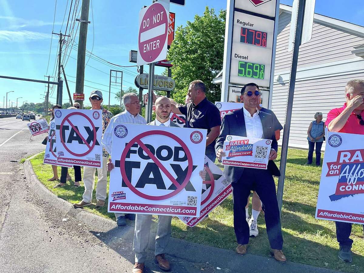 Connecticut Republicans including House Minority Leader Vincent Candelora, left back, state Rep. Joe Zullo, center, and state Sen. Paul Ciccarella, right, call for a suspension of the state's diesel tax at a rally outside Forbes Premium Fuel in East Haven on Tuesday, June 14, 2022.
