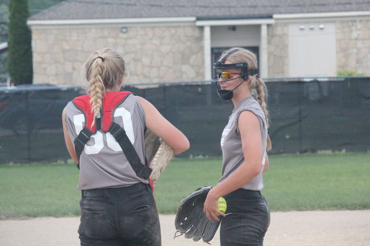 Reed City catcher Kaylin Goodman (left) and pitcher Isabell Guy discuss strategy during Wednesday softball action.