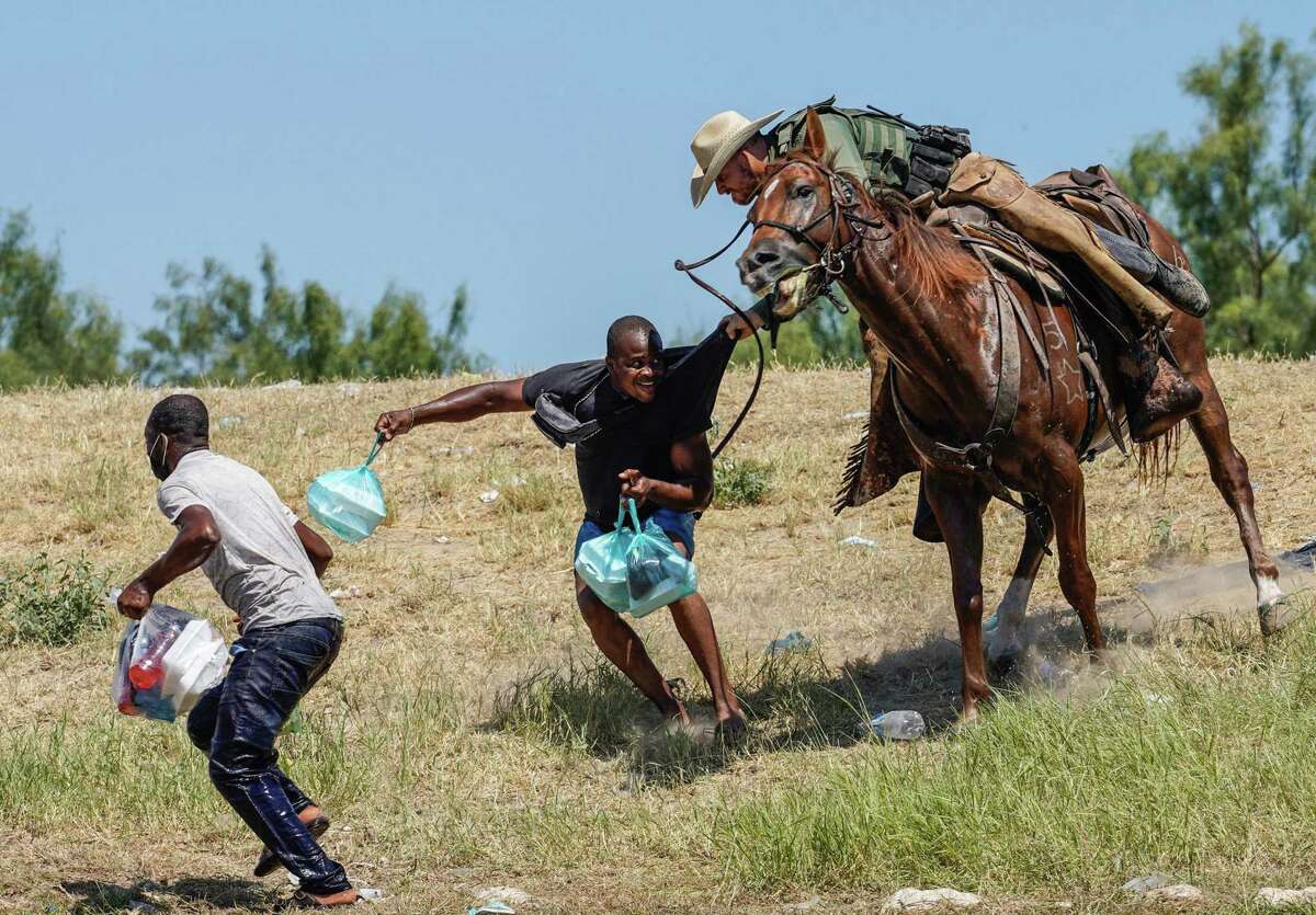 A coin circulating among U.S. Border Patrol agents depicts this scene, in which an agent on horseback tries to stop a Haitian migrant from entering an encampment on the banks of the Rio Grande in Del Rio, Texas, on September 19, 2021.
