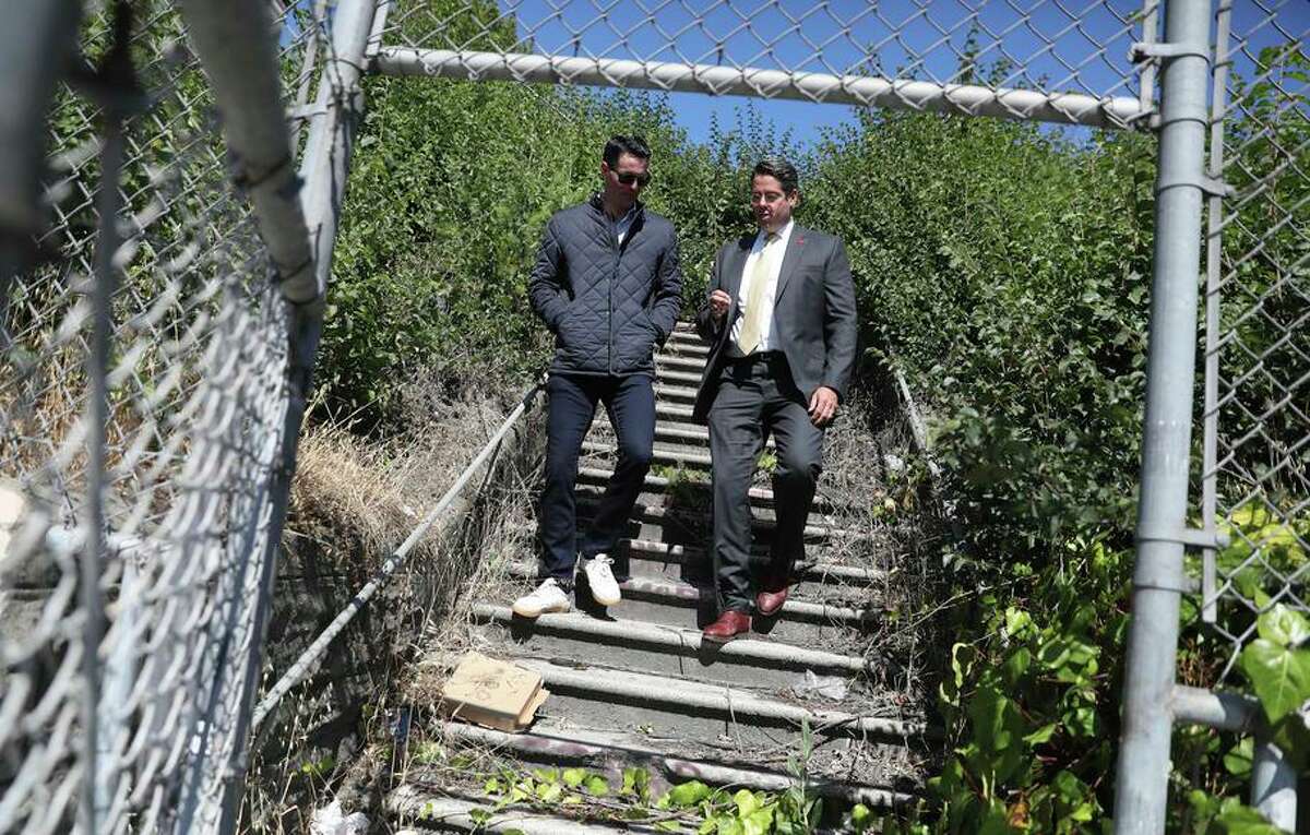 Joey Toboni (left) and Tim Szarnicki descend stairs on a lot on Third Street which they are hoping to develop into affordable housing.