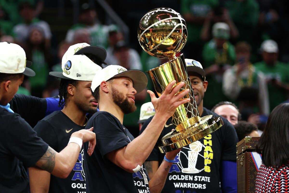 Stephen Curry #30 of the Golden State Warriors raises the Larry O'Brien Championship Trophy after defeating the Boston Celtics 103-90 in Game Six of the 2022 NBA Finals at TD Garden on June 16, 2022 in Boston.