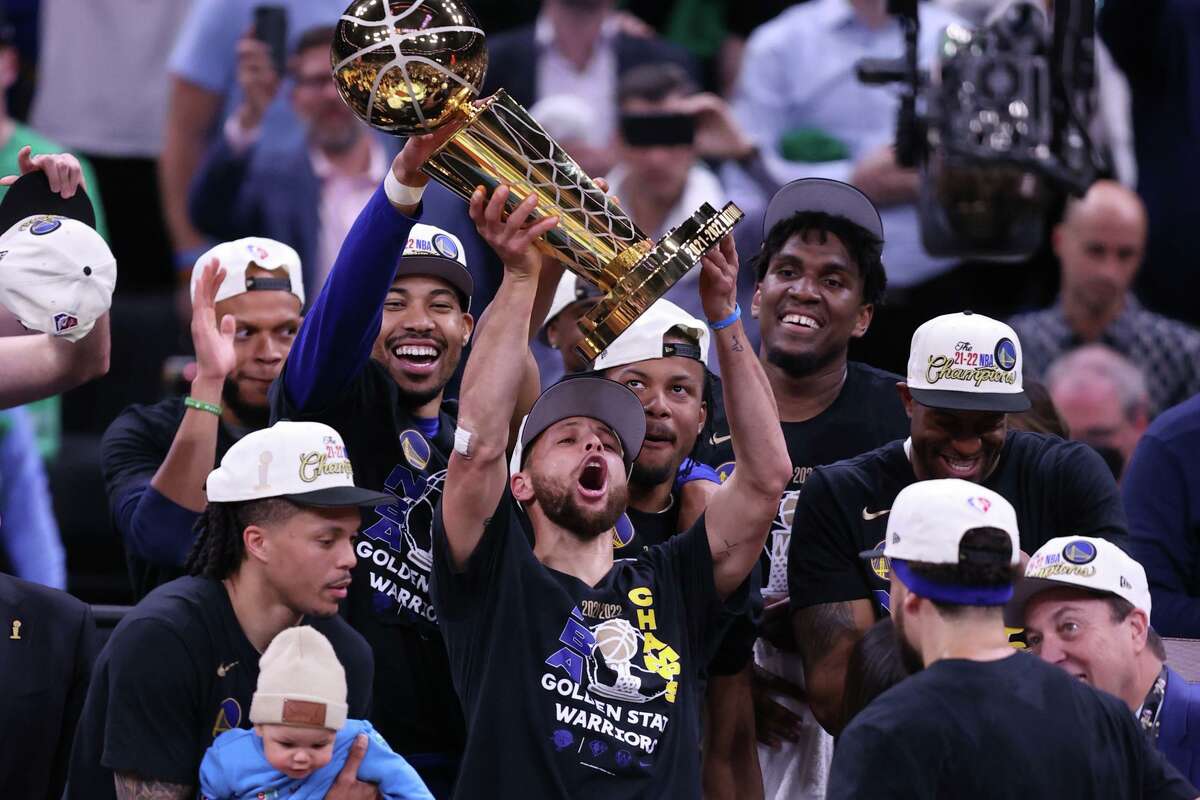 Golden State Warrior Stephen Curry raises the Larry O’Brien Trophy after the team defeated the Boston Celtics in Game 6 of the NBA Finals in Boston.