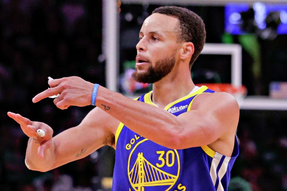 Golden State Warriors' Stephen Curry, 30, points to his ring finger as he walks up court during the third quarter in Game 6 of the NBA Finals at TD Garden in Boston, Mass., on Thursday, June 16, 2022.