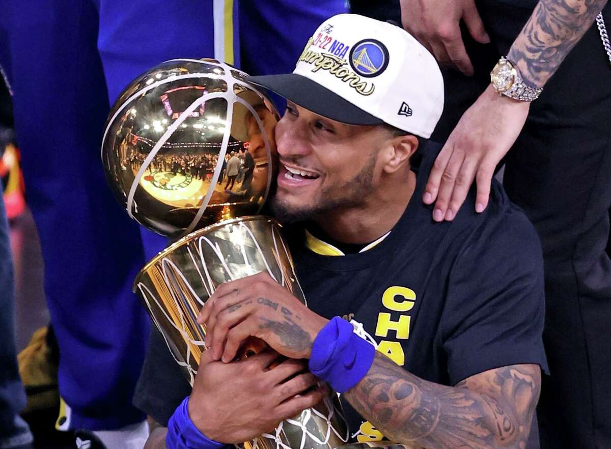 Golden State Warriors' Gary Payton II hugs the Larry O'Brien Trophy after Warriors' 103-90 win over Boston Celtics in Game 6 of NBA Finals at TD Garden in Boston Mass., on Thursday, June 16, 2022.