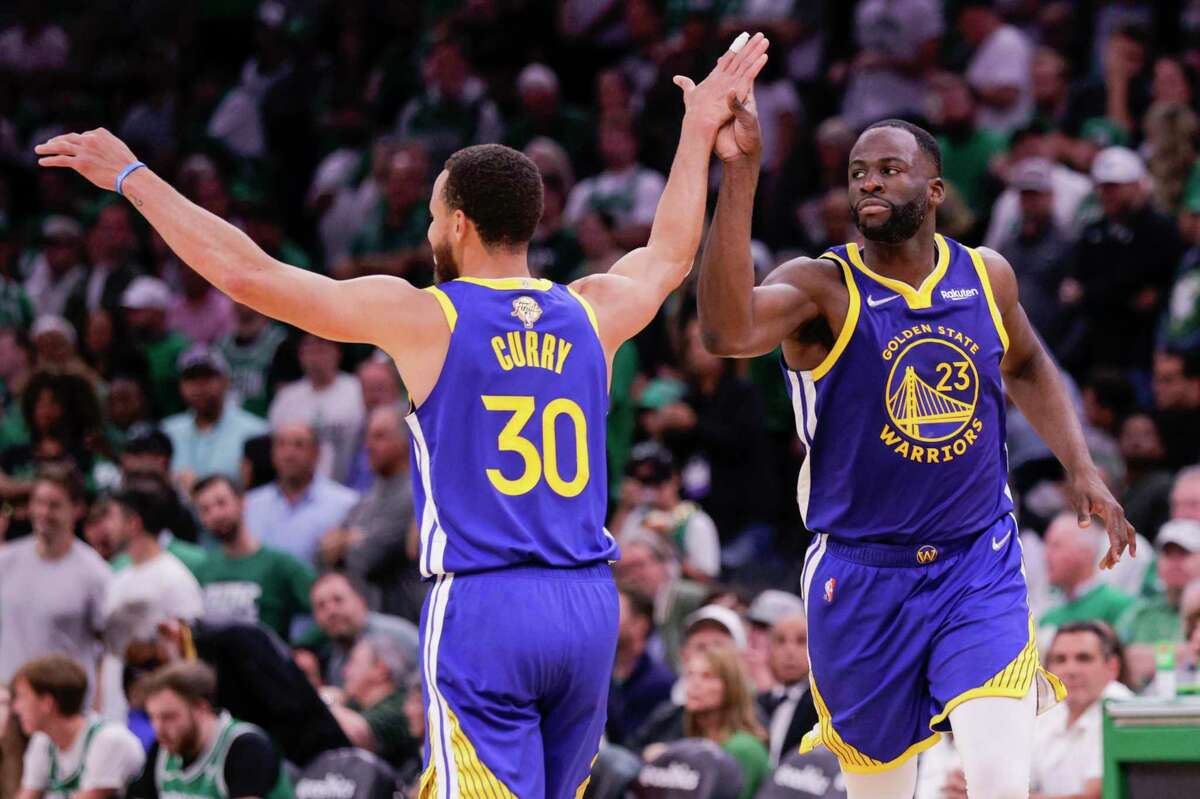 Golden State Warriors' Stephen Curry, 30, and Draymond Green, 23, high five during the third quarter in Game 6 of the NBA Finals at TD Garden in Boston, Mass., on Thursday, June 16, 2022.