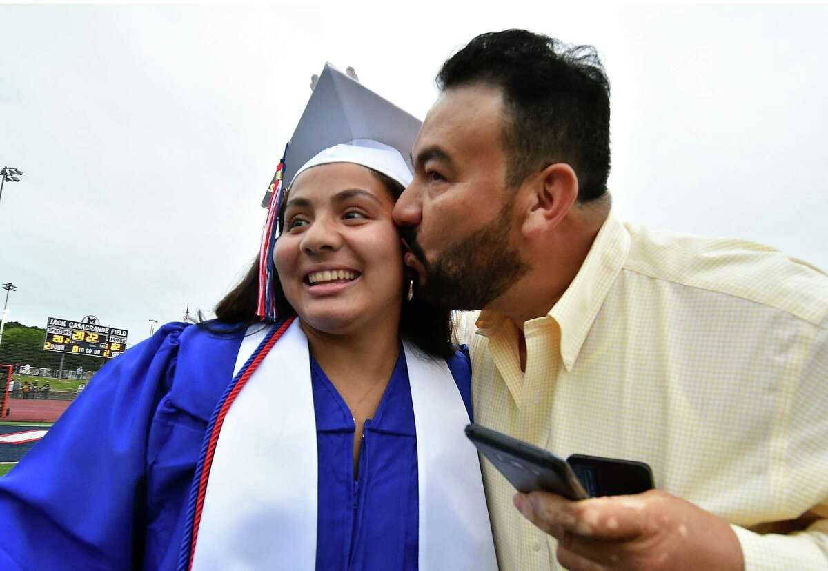 Hector Oseguera kisses his daughter Sylvia Sophia during Brien McMahon High School's 61st Commencement Exercises in Norwalk, Conn., on Thursday June 16, 2022.