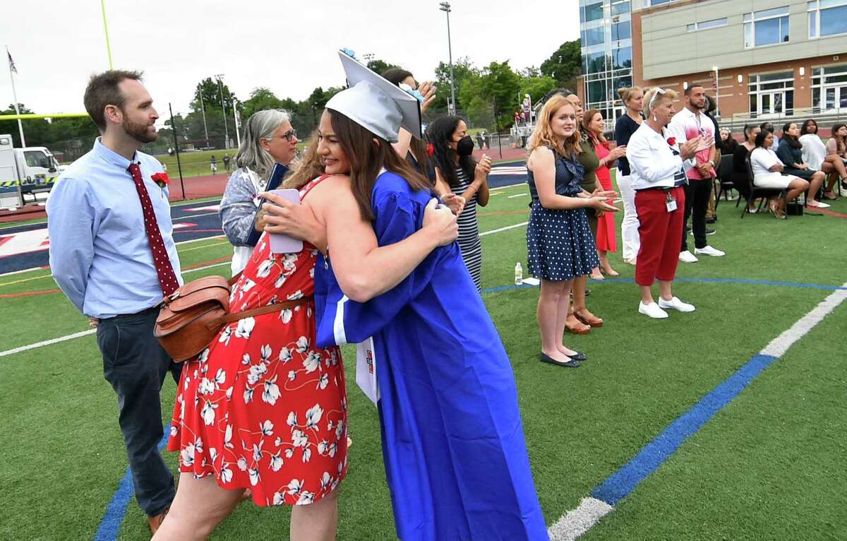 Graduate Nilser Flores hugs her teacher Melissa O'Donnell during Brien McMahon High School's 61st Commencement Exercises in Norwalk, Conn., on Thursday June 16, 2022.