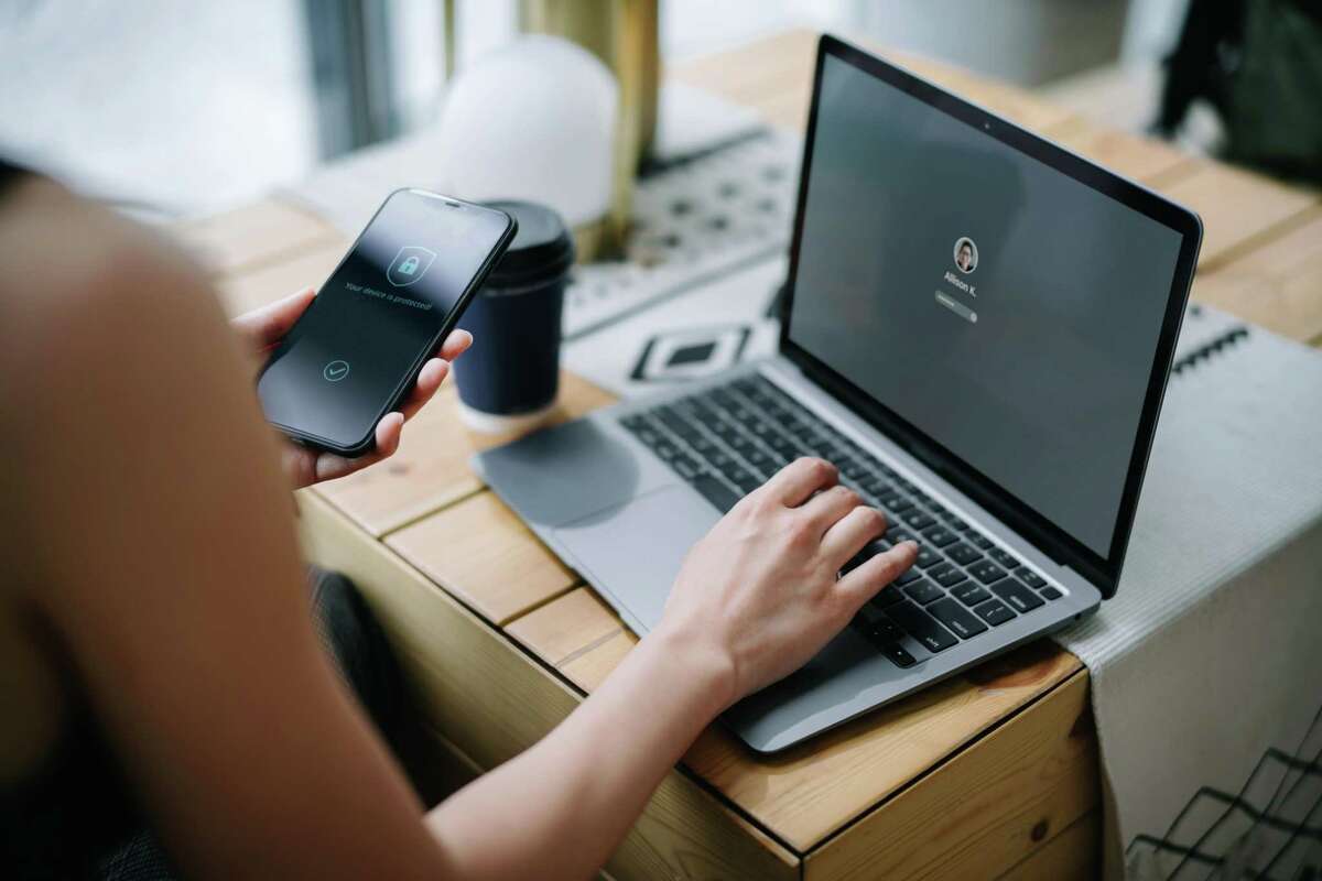 A businesswoman logging in to her laptop and holding a smartphone with a security key lock icon on the screen. Last month, Connecticut became only the fifth state in the nation to adopt a sweeping consumer data privacy bill.