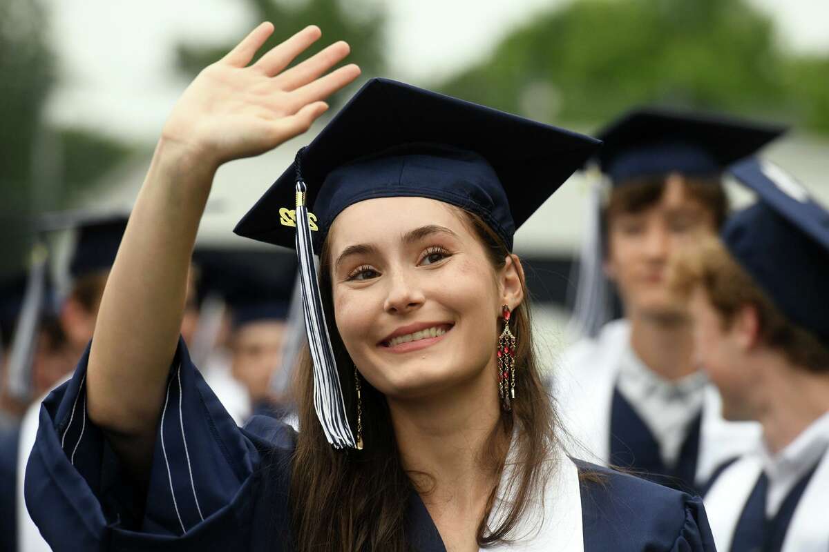 Juliette Savarino waves to family members at the start of Commencement for the Staples High School Class of 2022, in Westport, Conn. June 16, 2022.