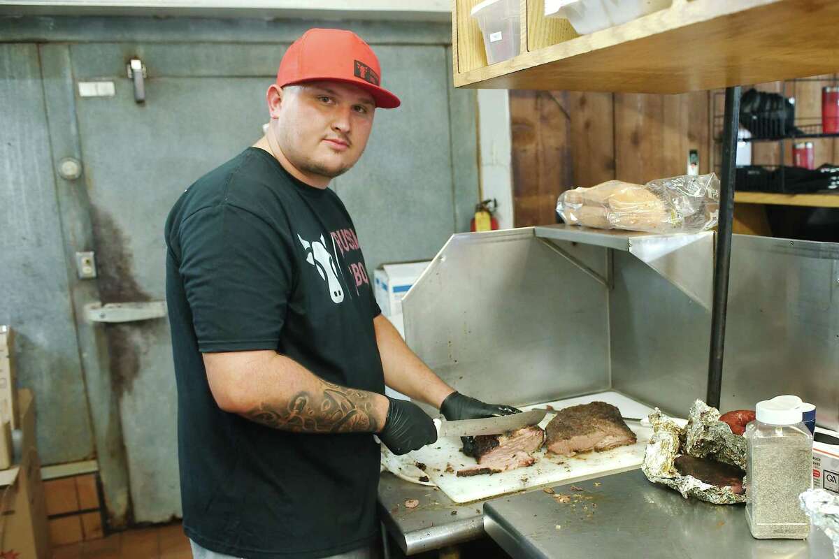 Bussin BBQ co-owner Kevin Phillips slices brisket at his new Deer Park restaurant. “My family had always told me I needed to start my own barbecue joint; so I decided I was going to do it,” he says.