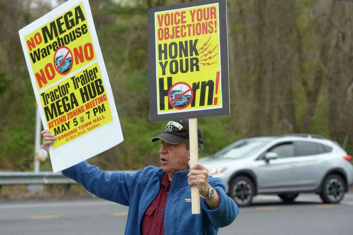Tulio Lopez, of Newtown, protests at Mount Pleasant and Hawleyville roads in Newtown over plans to build an 8-acre warehouse on 105 acres at Interstate 84’s Exit 9. The proposal was denied on June 16, 2022, by Newtown’s Planning and Zoning Commission.