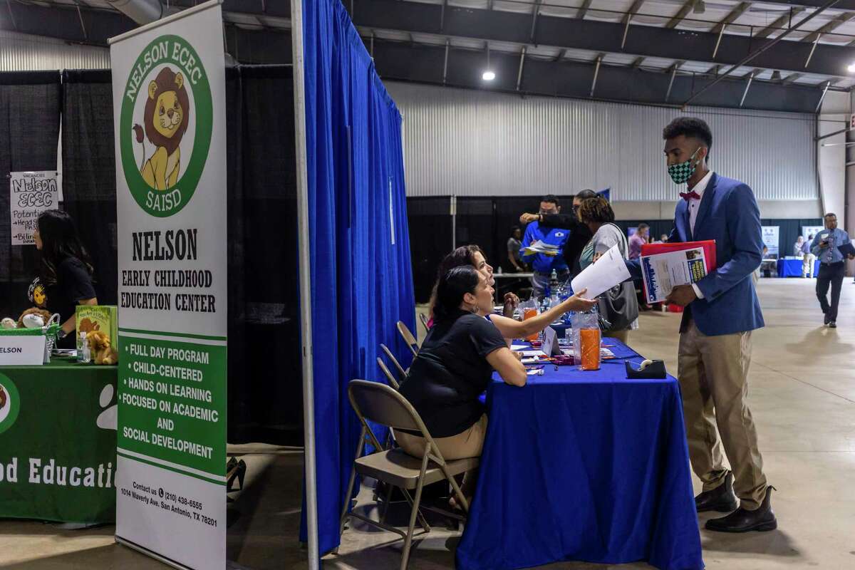 Andre Jeanjacques talks with a potential employer during the SAISD Job Fair held at Freeman Coliseum in San Antonio, Texas, on May 21, 2022.
