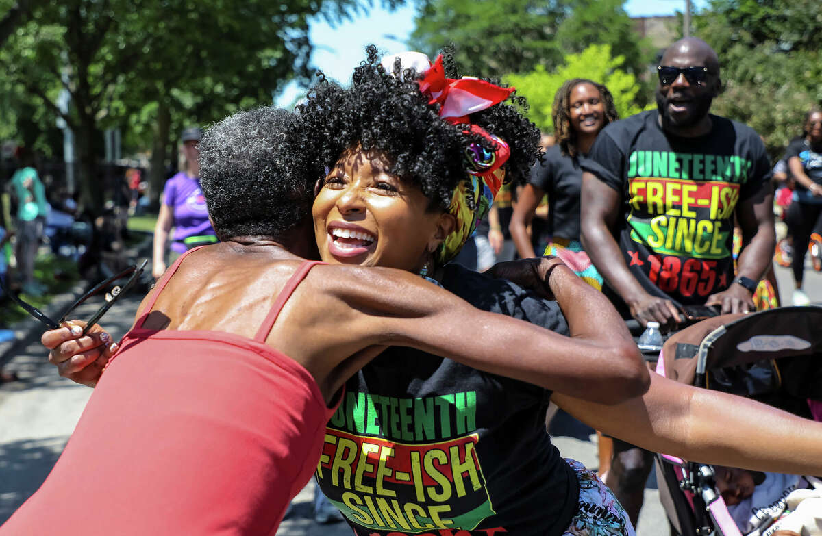 A participant hugs a spectator on June 19, 2021, during an annual celebration of Juneteenth in Evanston. 