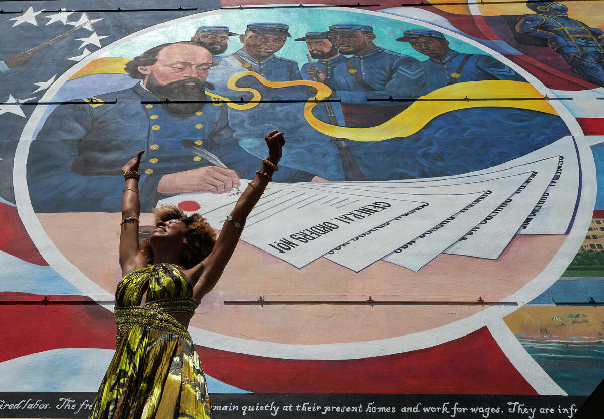 Dancer Prescylia Mae of Houston performs June 19, 2021, during a dedication ceremony for the mural "Absolute Equality" in downtown Galveston, Texas. Recognition of Juneteenth, the effective end of slavery in the U.S., gained traction after the police killing of George Floyd in 2020. But after an initial burst of action, the movement to have it recognized as an official holiday in the states largely has stalled.