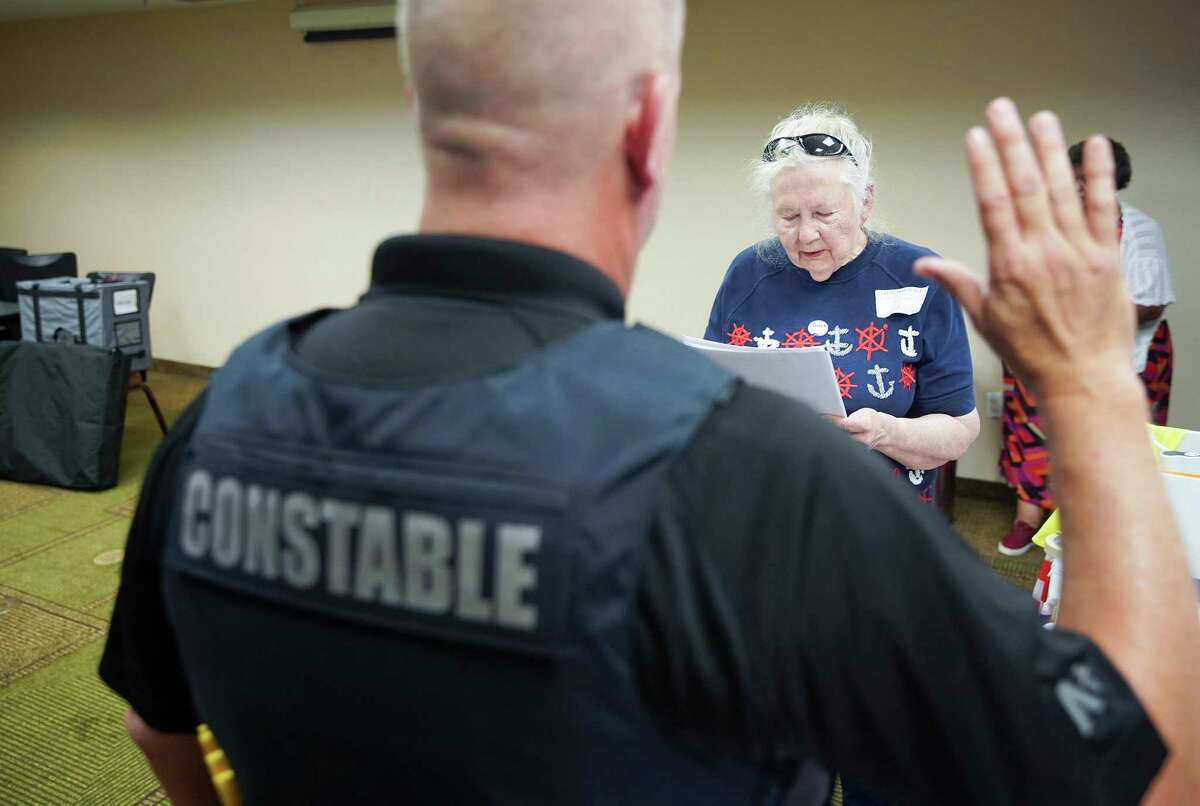 Harris County election judge Poppy Northcutt swears in a constable who will be driving the ballots to NRG Arena at the end of the day a voting site for the primary runoff election at La Quinta Inn near the Galleria in Houston on Tuesday, May 24, 2022.