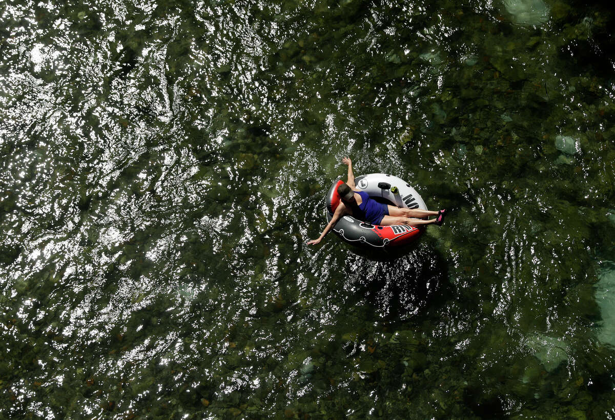 Beating the heat, a tuber floats the cool Comal River on Thursday, July 18, 2019, in New Braunfels. 