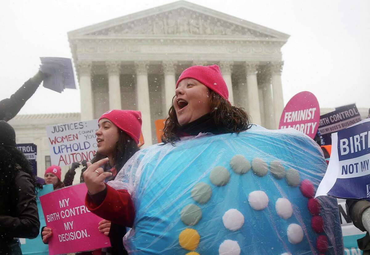 A protester wears a birth control pill costume as she protests in front of the Supreme Court in Washington in 2014.