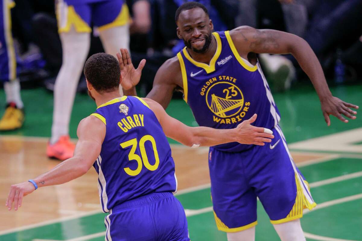 Golden State Warriors' Draymond Green, 23, and Stephen Curry, 30, begin to celebrate during the fourth quarter in Game 6 of the NBA Finals at TD Garden in Boston, Mass., on Thursday, June 16, 2022. The Golden State Warriors defeated the Boston Celtics 103 to 90 in the NBA Finals.