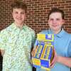Trumbull High sophomores Alex Delales, left, and Sam DiVasto hold a store display loaded with their Freedom Bars, chocolate bars they are selling as a fundraiser for Ukraine relief, in Trumbull, Conn. on Tuesday, June 14, 2022.