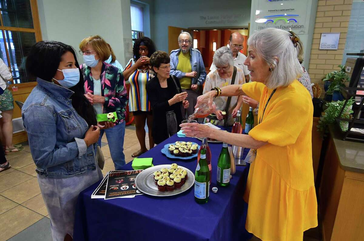 Pat Sheary, Head of Adult Programs at the Darien Library, at right, serves light drinks and cupcakes during The Ubuntu Storytellers celebration of Juneteenth with "Victory and Jubilation: Stories of Liberation Despite..." at the Darien Library Community Room in Darien, Conn., on Wednesday June 15, 2022. The Ubuntu Storytellers are a diverse group of Black, brown, and mixed-race professional storytellers. They will share stories of triumph and jubilation and their experiences with discrimination, racism, and microaggressions.