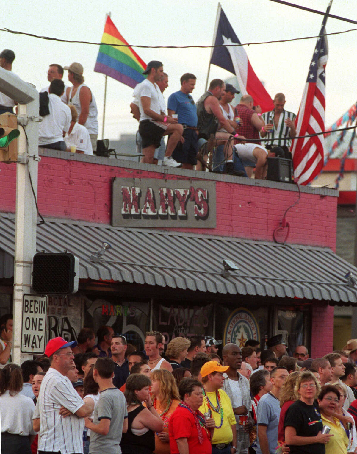 Parade goers crowd the sidewalk and roof of Mary's, a landmark gay bar in Houston's Montrose neighborhood.