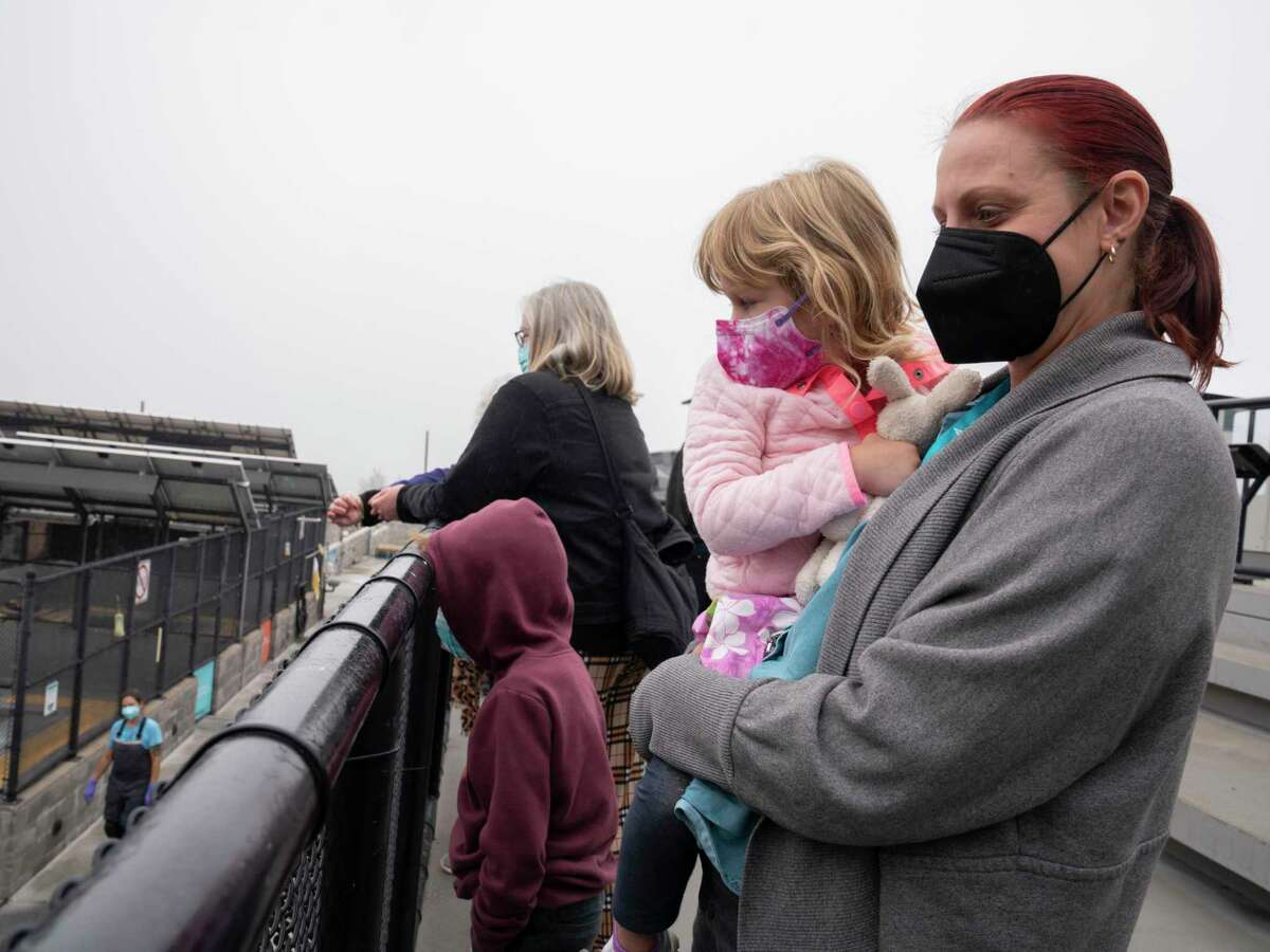 Even as seven of the nine Bay Area counties — all except San Francisco and San Mateo — remain in the CDC’s “high” community level of COVID, society continues to re-emerge from the pandemic. Here, a family looks at seals on reopening day earlier this month at the Marine Mammal Center in Sausalito.