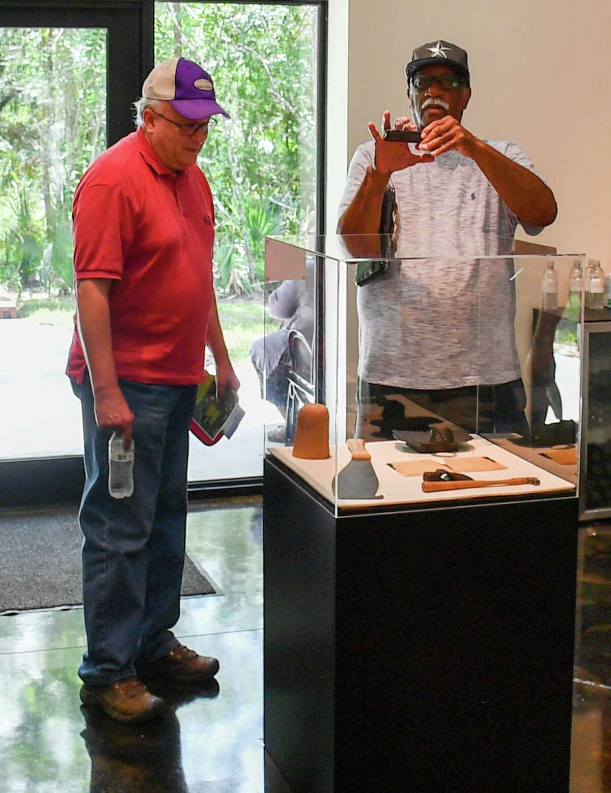 George Avery, left, and Archie Rison discuss the artifacts on display at the visitor’s center at the Levi Jordan Plantation State Historic Site during the site’s reopening event June 11, 2022.