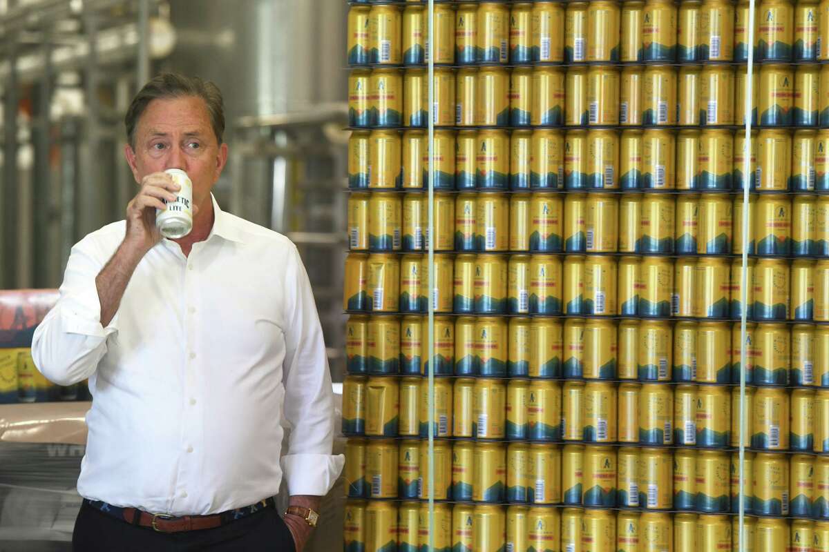 Gov. Ned Lamont takes a sip of a non-alcoholic beer prior to speaking during a ribbon cutting ceremony at Athletic Brewing Company’s new brewery, in Milford, Conn. June 17, 2022.