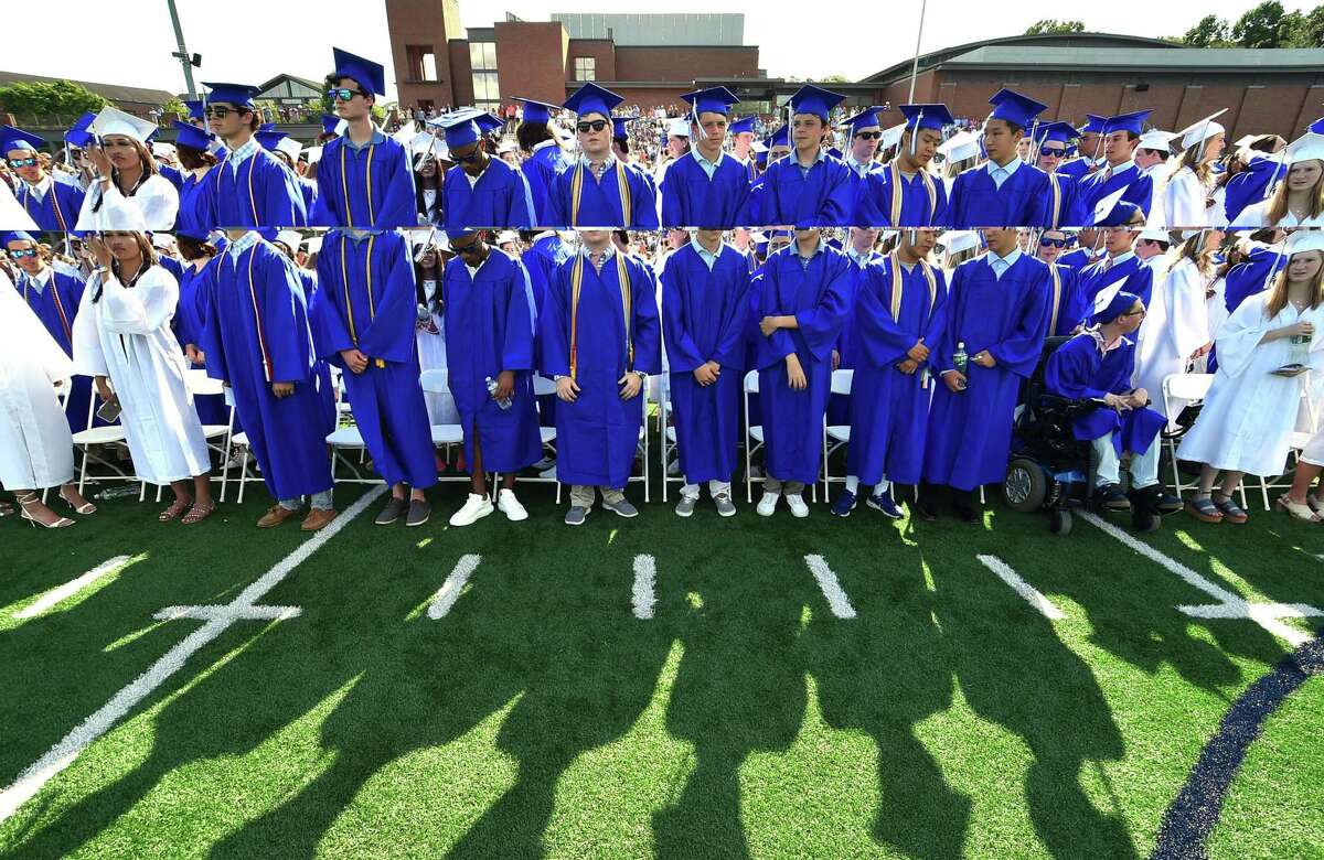 Graduates cast shadows onto the field during Darien High School's Class of 2022 Commencement Program in Darien, Conn., on Friday June 17, 2022.