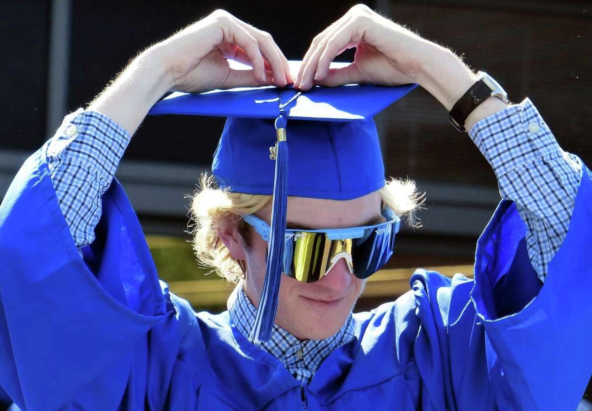 Neil Flynn adjust his graduation cap before the start of Darien High School's Class of 2022 Commencement Program in Darien, Conn., on Friday June 17, 2022.