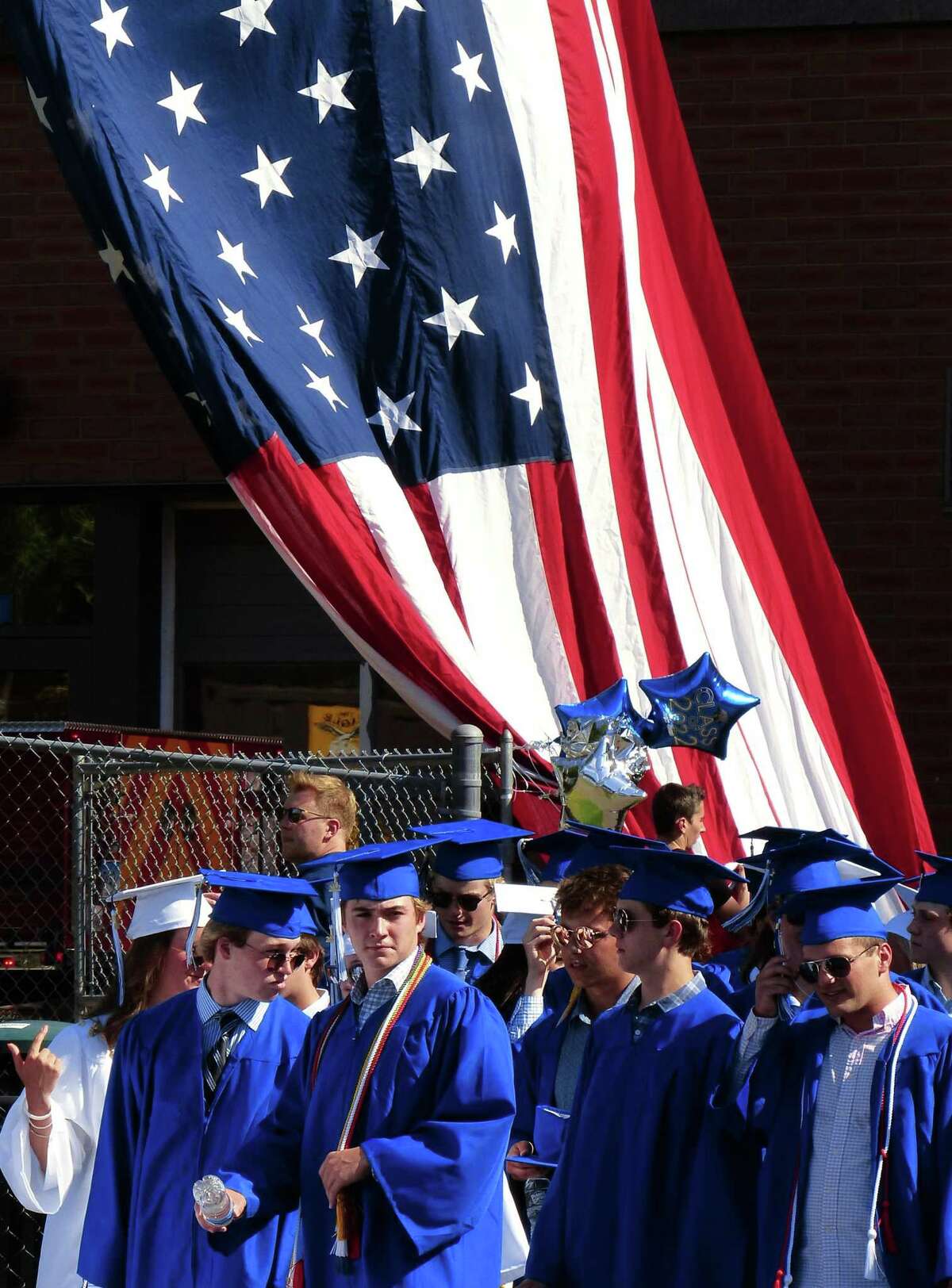 The US flag flies from a Darien fire truck as graduates file in at the start of Darien High School's Class of 2022 Commencement Program in Darien, Conn., on Friday June 17, 2022.