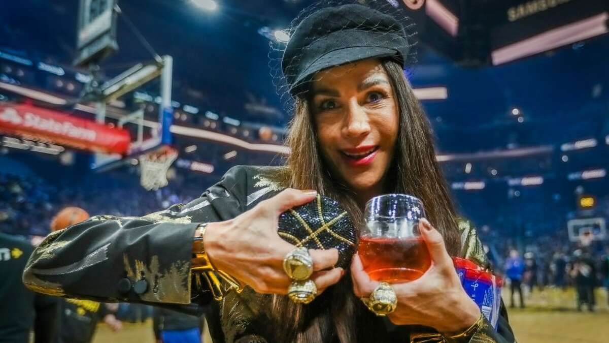 Nicole Karan poses in the first three championship rings before this spring's Warriors playoff game.