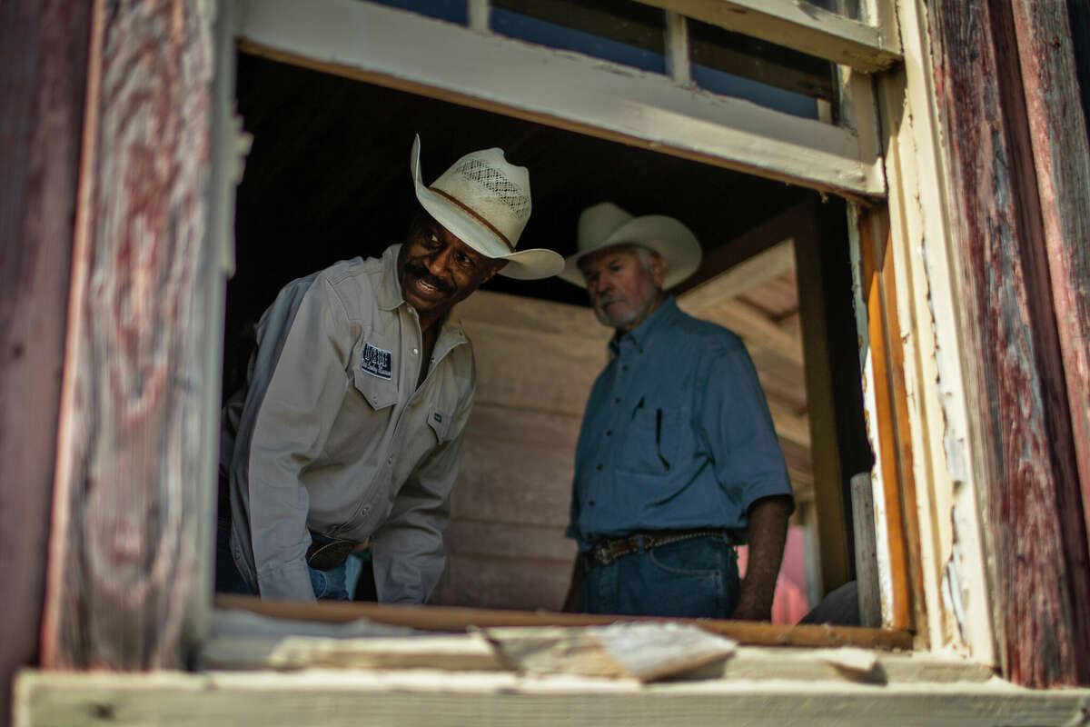 Larry Callies, left, and Bud Northington, right, tour the inside of a slave quarters in Northington's family land, Friday, June 17, 2022, in Egypt. Callies says Northington is a descendant of a slave owner who owned, and bred with, Callies's lineage. Callies will be staying overnight in the preserved slave quarters and former plantation of Northington's relatives. Callies owner of the Black Cowboy Museum in Rosenberg.