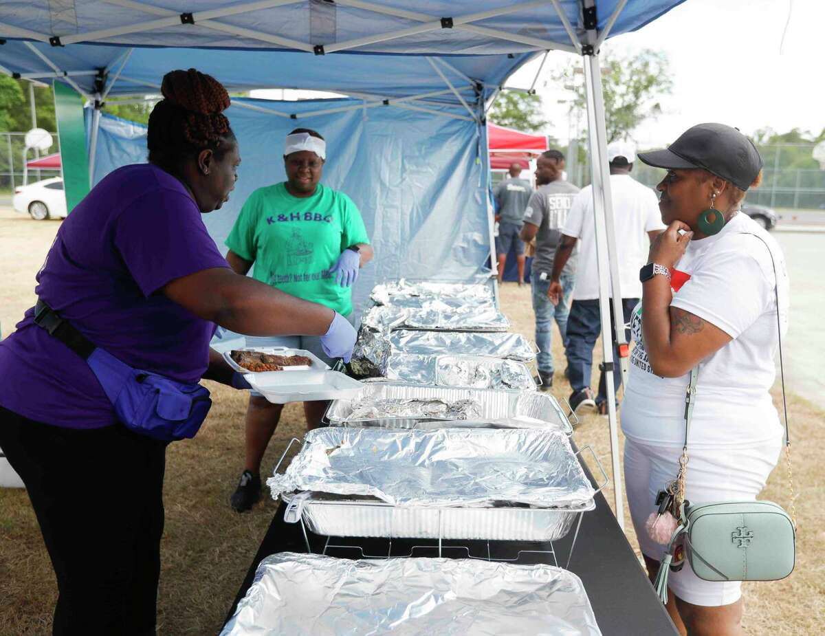 Faith Daniels, with K & H BBQ, makes a plate of food for Shelia Ashley during Good Brothers and Sisters of Montgomery County’s Juneteenth celebration, Saturday, June 18, 2022, in Conroe.