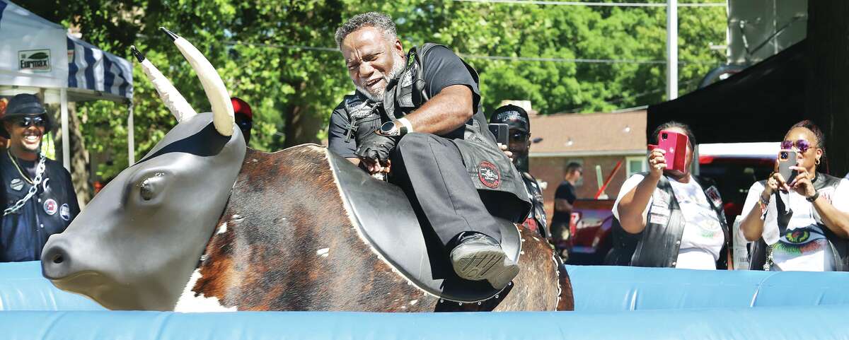 Beacon Williams of St. Louis struggles to hold on to the mechanical bull Saturday at the 31st annual Alton Juneteenth celebration in James H. Killion Park in Upper Alton. Good weather brought out large crowds to the celebration of the end of slavery in the United States on June 19, 1865.