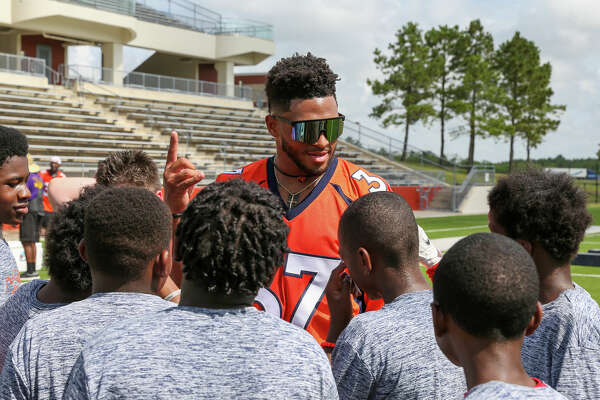 University of Texas running back Roschon Johnson talks to a group of young athletes at P.J. Locke's football camp at Beaumont Memorial Stadium. Photo made Saturday, June 18, 2022 by Jarrod Brown