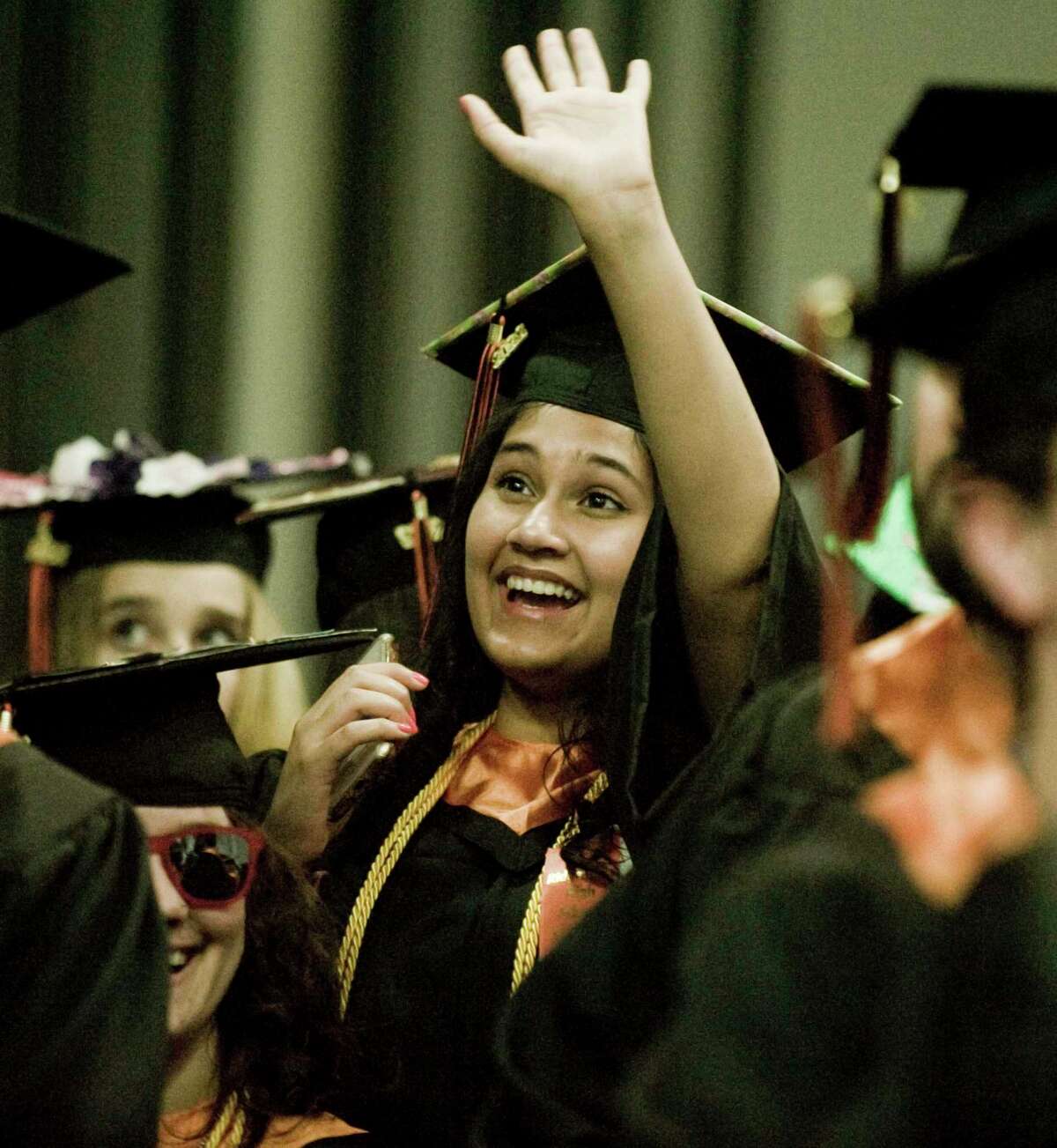 Kavya Anand waves to a familiar face in the crowd during the Ridgefield High School graduation at the O'Neill Center. Friday, June 17, 2022
